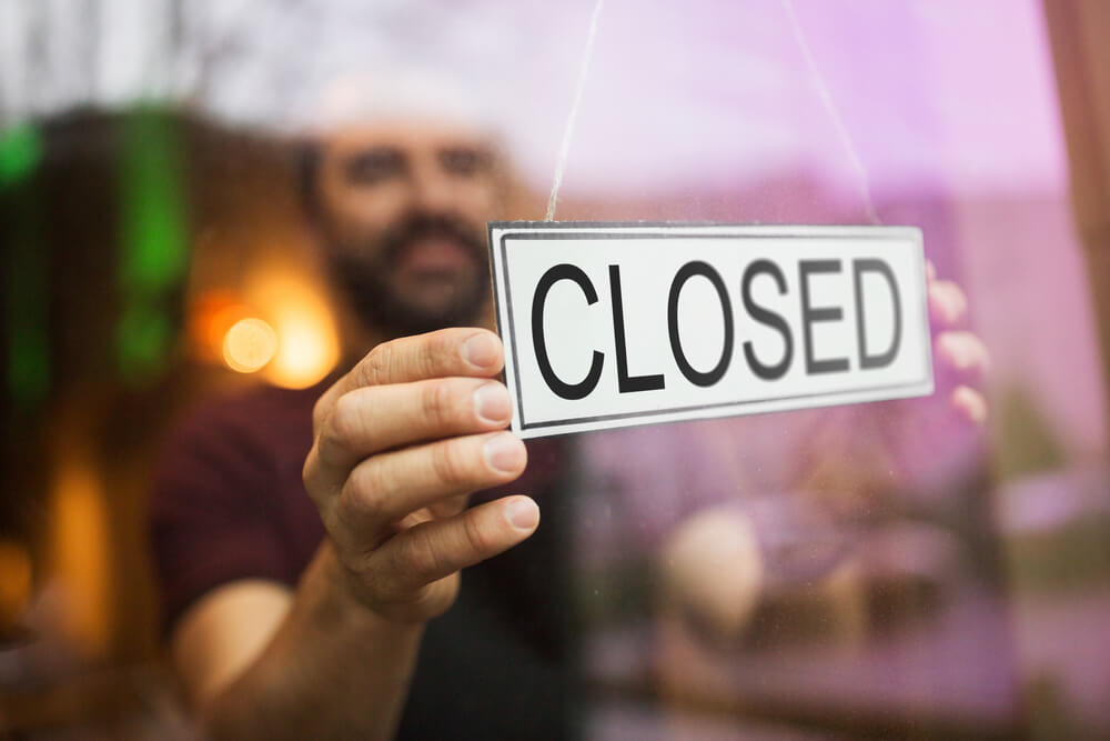 Man holding a closed sign