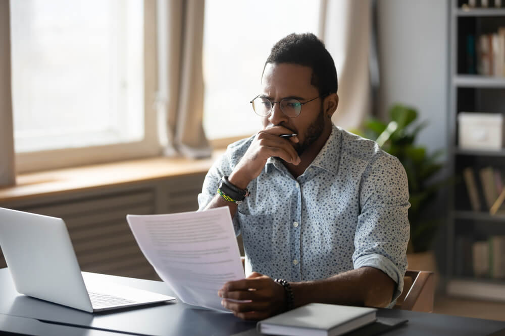 Business man thinking while holding paper